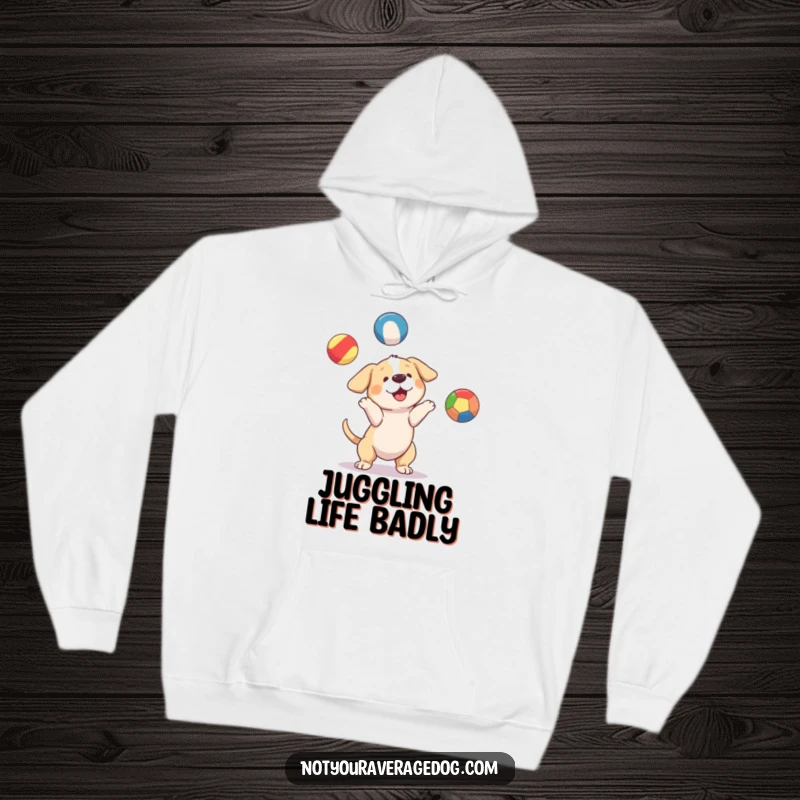 Funny dog attempting to juggle three mismatched, brightly colored balls, a warm and humorous hoodie for ultimate comfort.